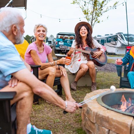 happy group of campers talking around the campfire